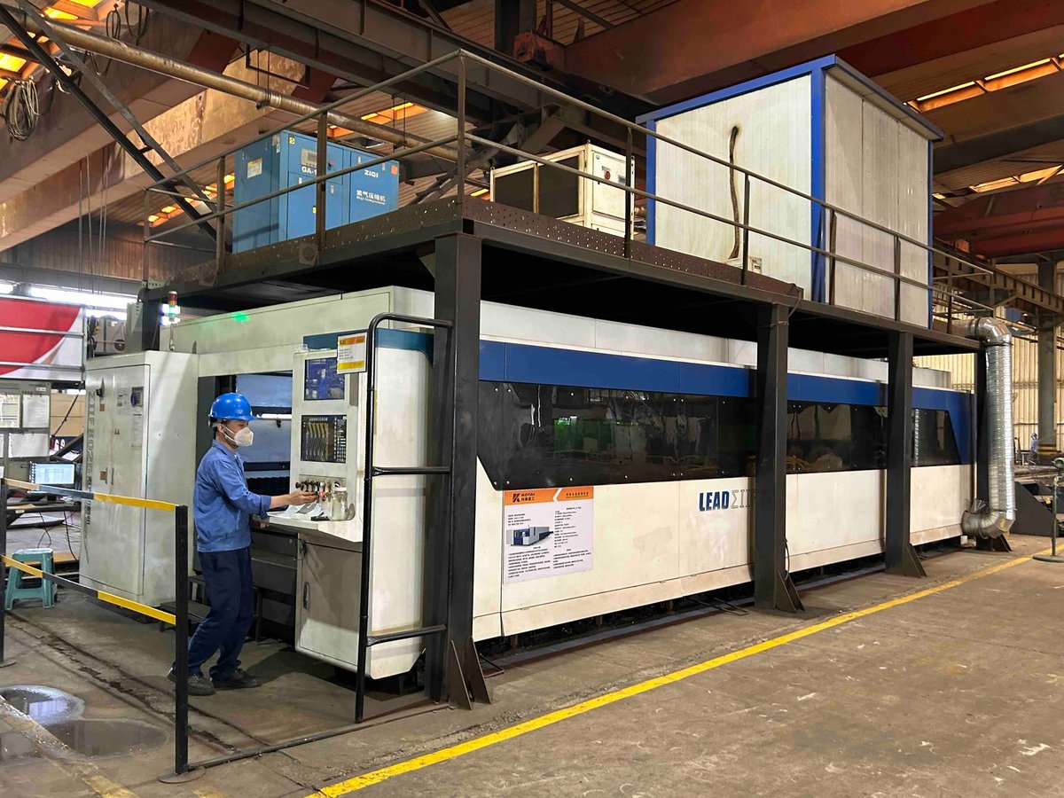 Industrial factory worker operating control panel of a large manufacturing machine with blue and white paneling in a warehouse
