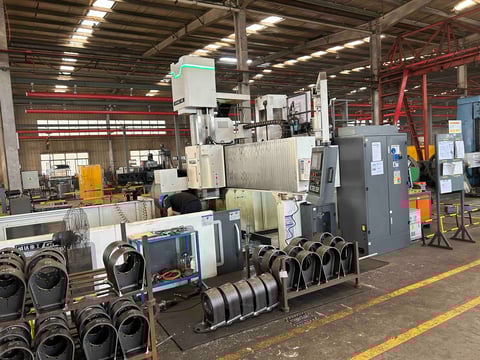 Industrial warehouse with CNC machinery, metal parts, electrical equipment, and industrial machinery staged for auction or sale